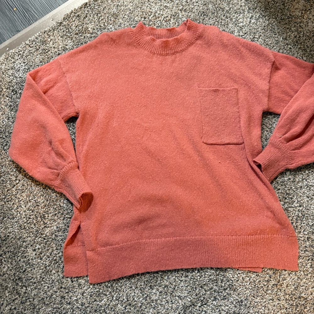 Coral colored pocket detail sweater.